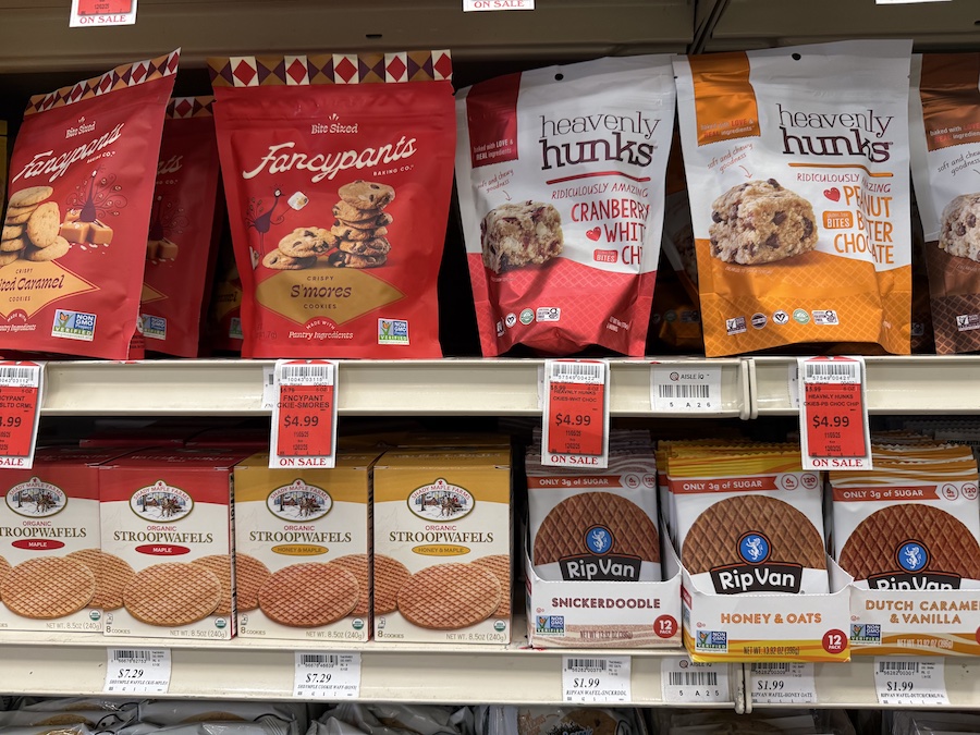 Brightly packaged Fancypants cookies and soft-baked Heavenly Hunks bites arranged on a well-lit display.