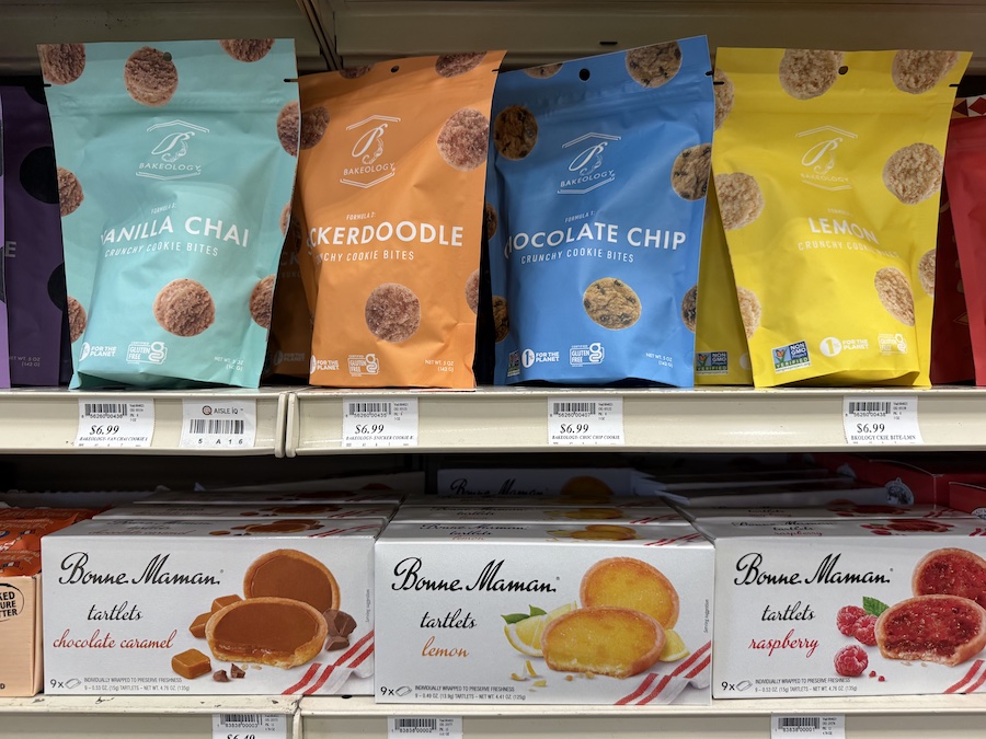 Shelves filled with Bakeology and Bonne Maman cookies, showcasing indulgent flavors in eco-friendly packaging.