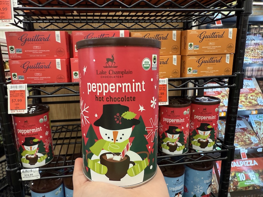 A shopper holding a tin of Lake Champlain Chocolates Peppermint Hot Chocolate at Mother’s California Market