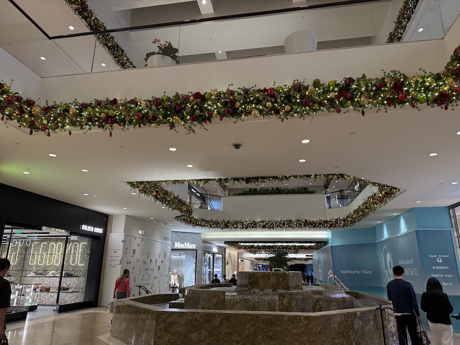 Luxurious Christmas decorations throughout the mall, including garlands, twinkling lights, and oversized ornaments.