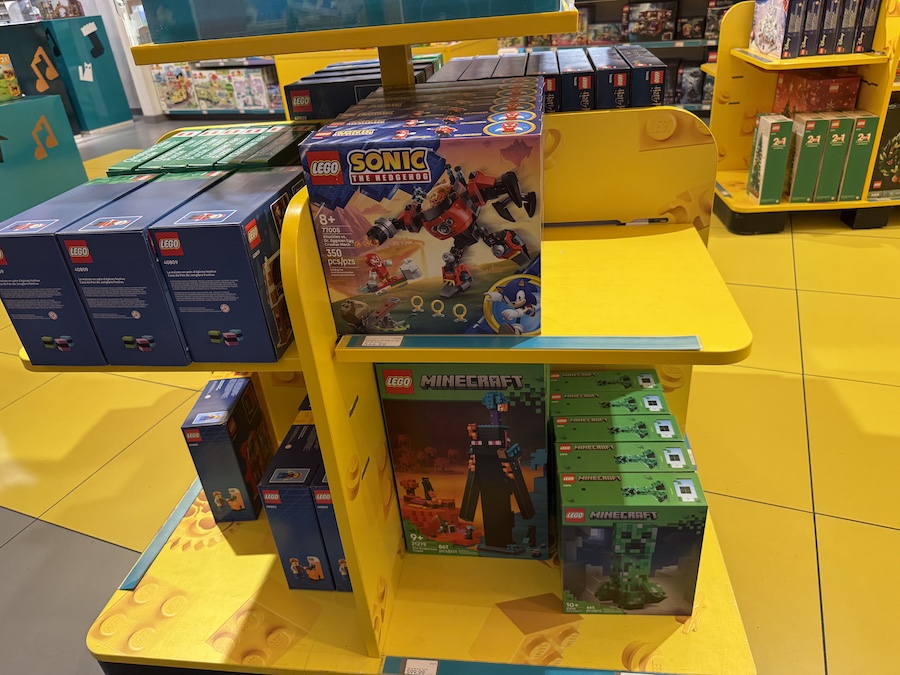 A LEGO Sonic the Hedgehog set showing Knuckles in battle against Dr. Eggman’s Egg Crusher Mech, positioned on the store shelf with bright packaging.