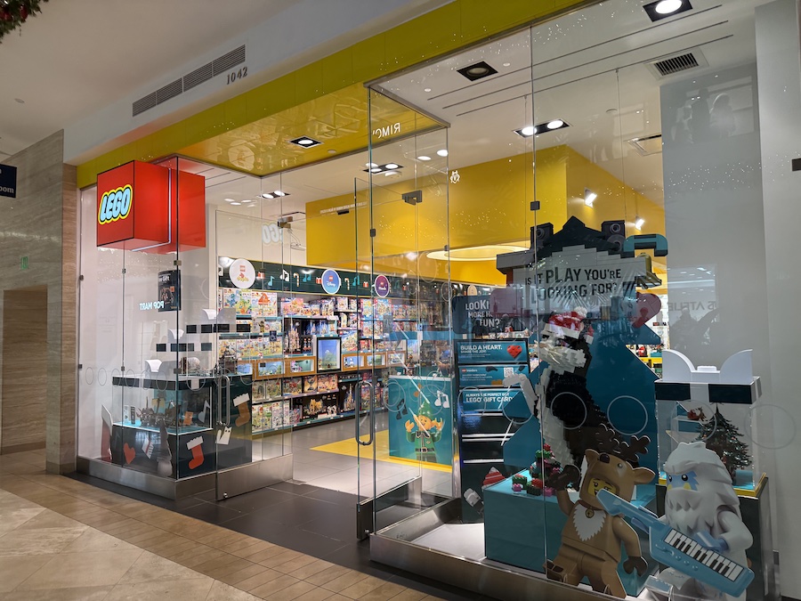 The LEGO store entrance featuring bright yellow accents, colorful models in the window.