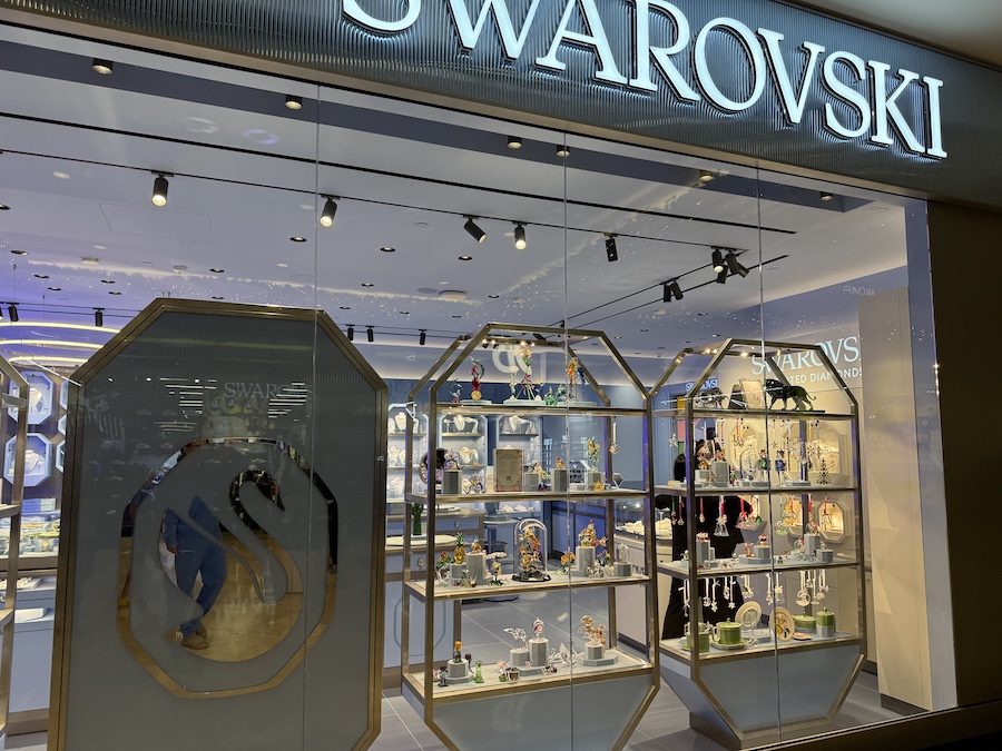 The Swarovski boutique featuring glittering crystal ornaments, jewelry displays, and festive decorations reflecting the brand’s signature sparkle.