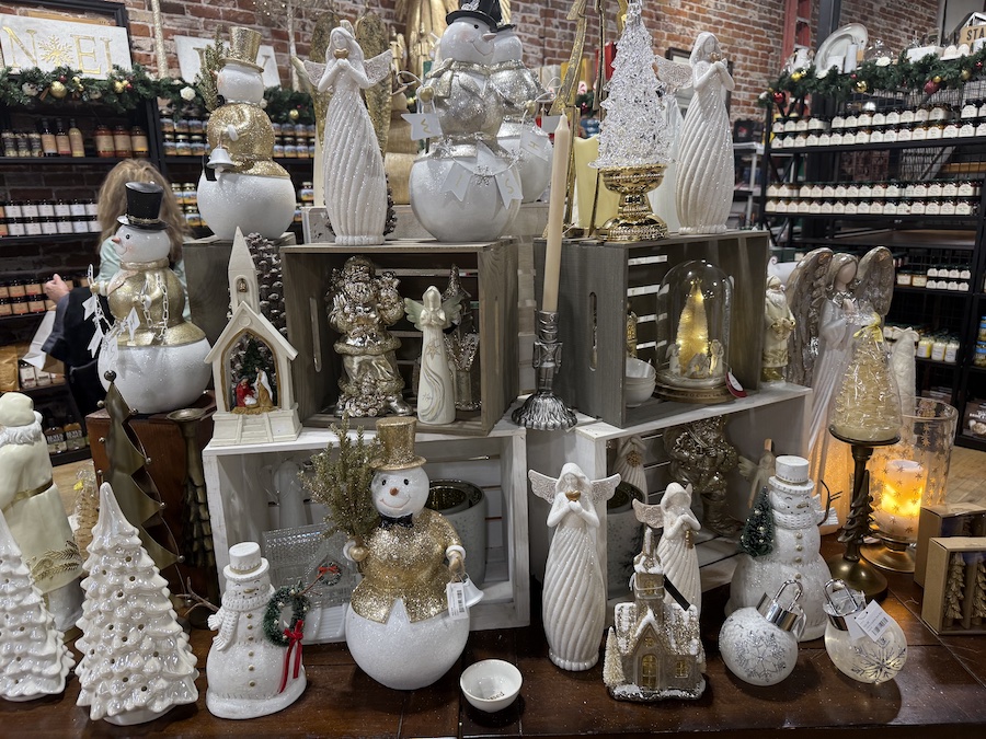 Ceramic angel and snowman figurines lined up together, adding classic holiday elegance.
