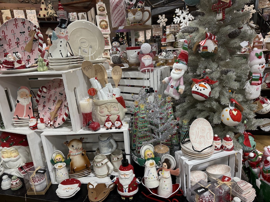 Colorful Christmas plates with holiday illustrations arranged in a cheerful display inside Spice Traveler.