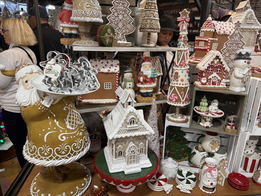 Ceramic gingerbread trees and house figurines arranged together as a charming holiday village display.