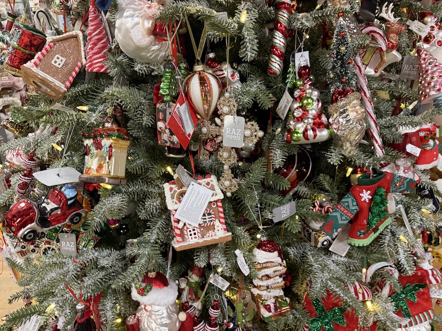Raz Imports holiday ornaments arranged on the Christmas display tree, featuring detailed, high-quality designs.
