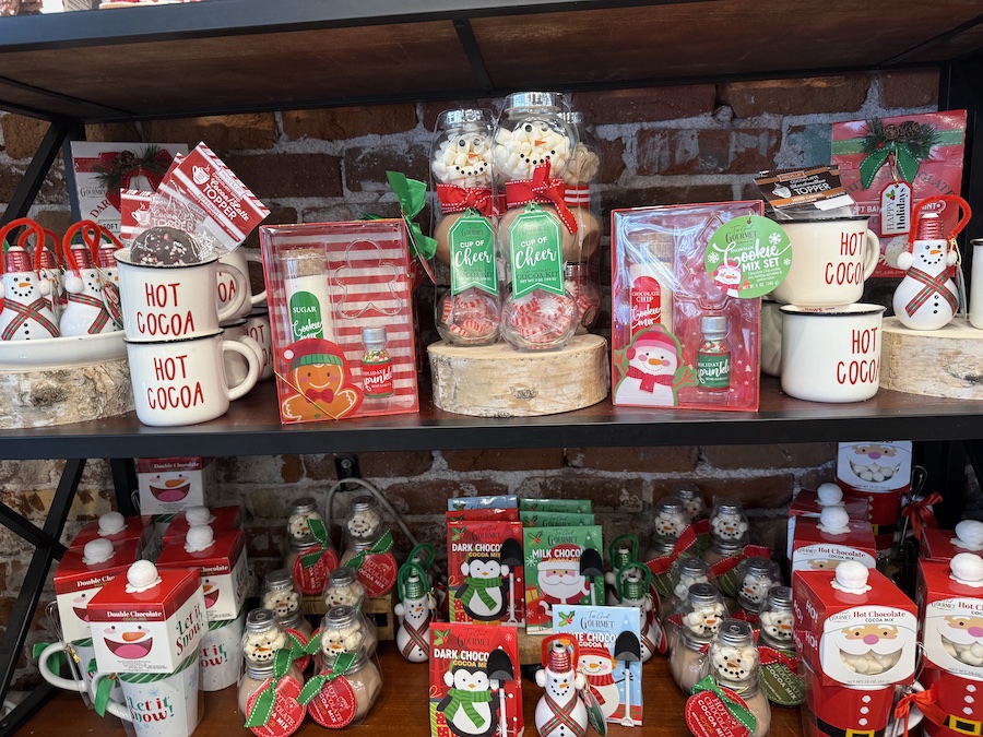 A charming “Cup of Cheer” hot chocolate kit by Too Good Gourmet displayed among holiday beverage gifts.