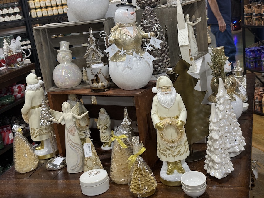 A shelf filled with festive Christmas figurines and winter décor at Spice Traveler Prescott.