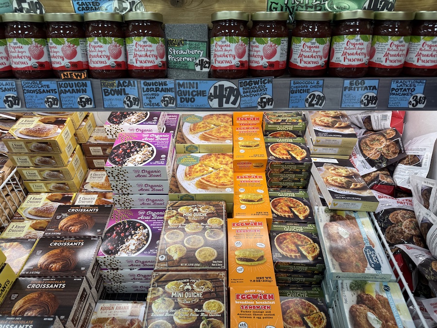 A freezer section packed with flaky croissants, quiche duos, açai bowls, eggwiches, and broccoli cheddar quiche options.