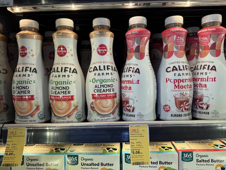 Califia Farms almond creamers in sleek bottles with minimalist designs lined up in the refrigerated section.