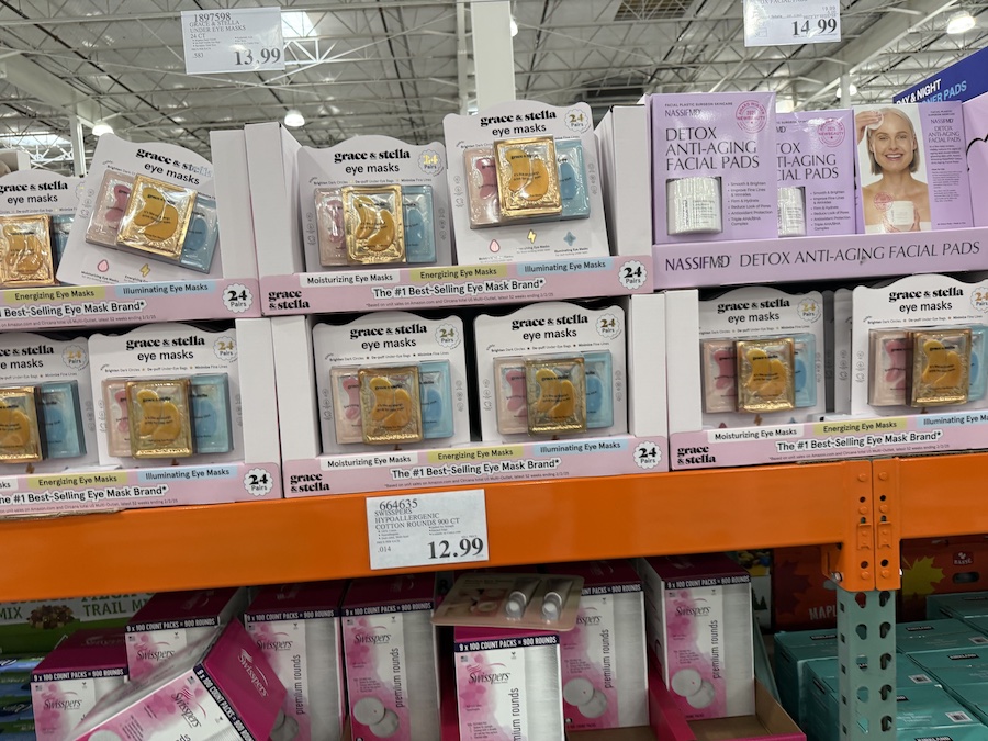 A stack of bright, colorful boxes containing Grace & Stella under-eye masks, featuring multiple varieties in one pack.