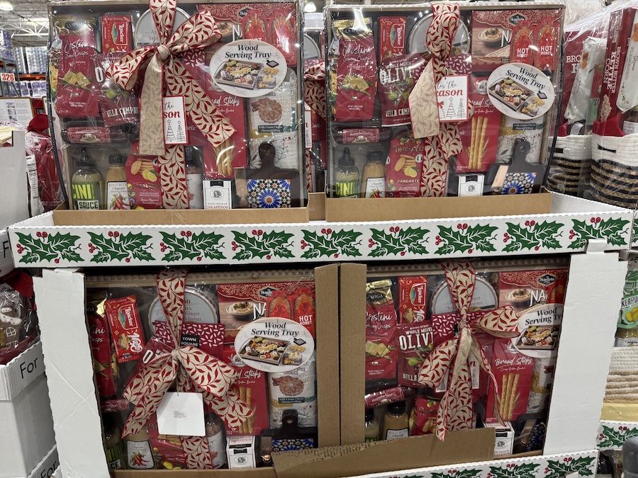 A tray packed with snacks and chocolates, decorated with wooden bead trim.
