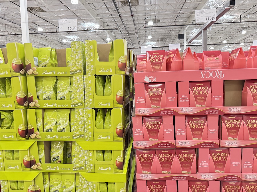 Lindt Lindor Pistachio Truffles and Almond Roca Gable Top Box displayed side-by-side on a Costco shelf.