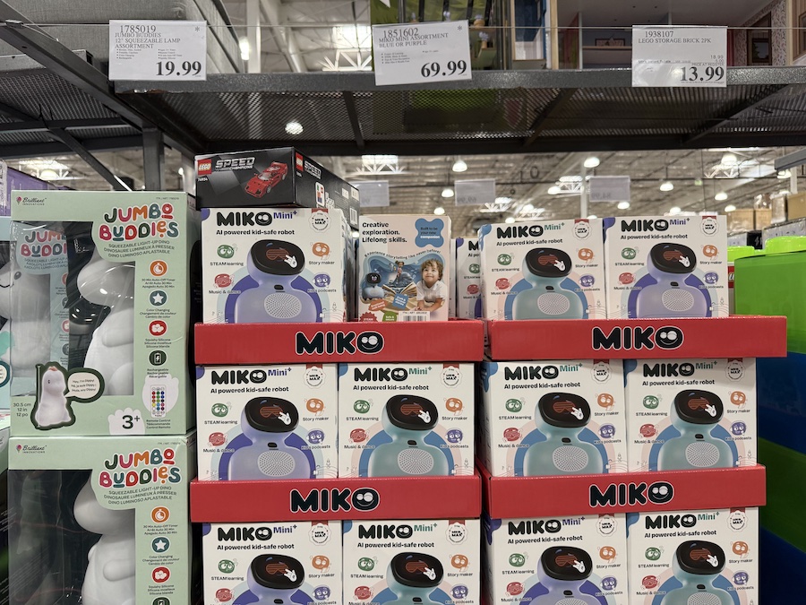 A shelf display of small Miko Mini AI robots in various colors