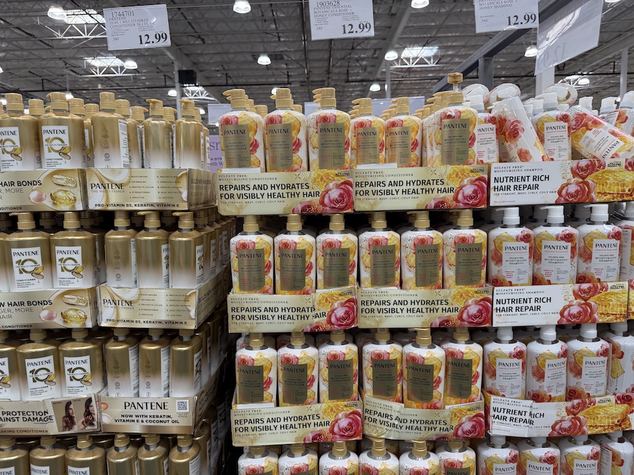 A jumbo bottle of Pantene conditioner with botanical artwork and a soft pink label.
