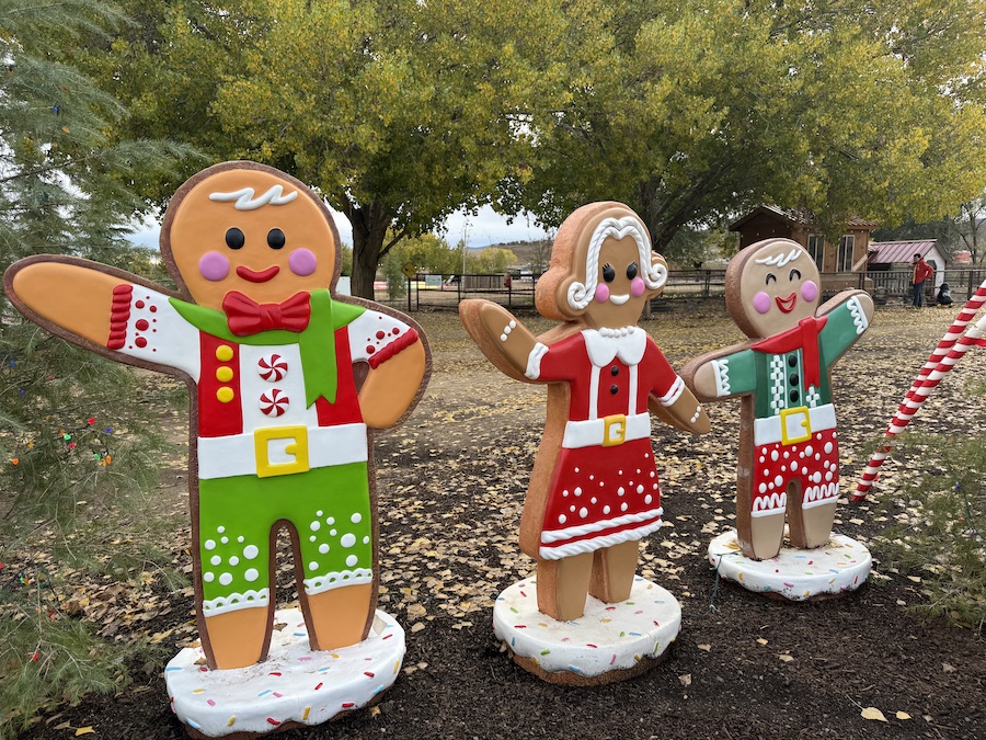 Cute gingerbread family figures arranged in the yard, creating a whimsical and cheerful holiday scene.