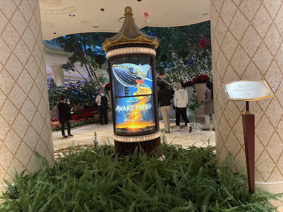 A poster for Awakening surrounded by holiday decorations in the Wynn hallway.