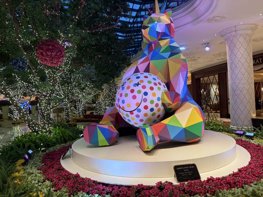 The Smiling King Bear sculpture surrounded by holiday greenery.
