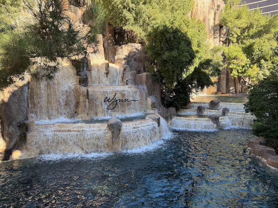 A serene waterfall feature at Wynn Las Vegas, surrounded by lush greenery and rocks.