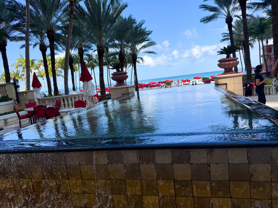 Oceanfront fountain terrace at Acqualina Resort with palm trees and beach views.