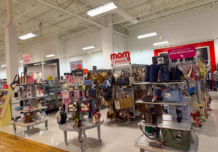 Designer handbags and fashion accessories displayed at TJ Maxx, a popular source for affordable gift shopping.