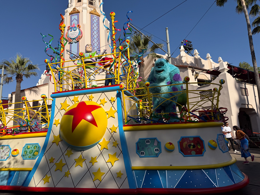 Buzz Lightyear and Sulley riding on a Pixar celebration float at Disney California Adventure