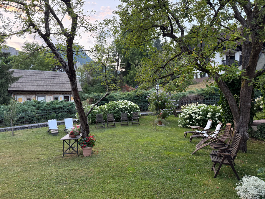 Peaceful garden lawn with wooden loungers and flowering hydrangeas at Kendov Dvorec