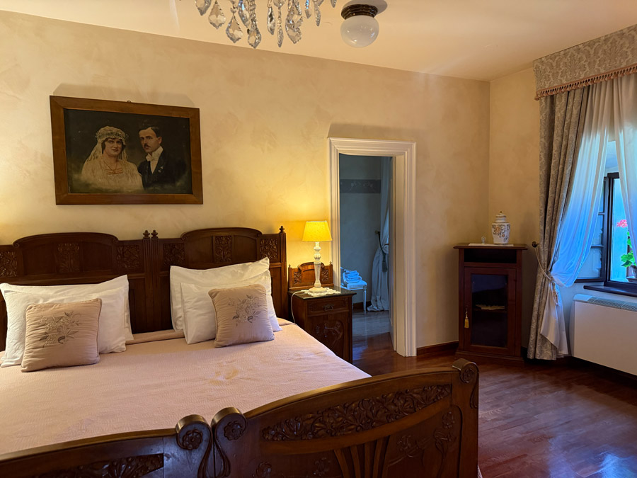 Kendov Dvorec bedroom with a carved wooden bed, antique furniture, and traditional decor