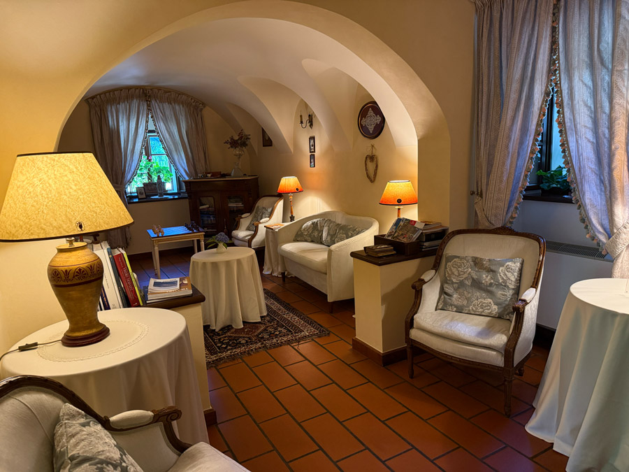 Historic lounge at Kendov Dvorec with arched ceilings, antique chairs, books, and warm lighting