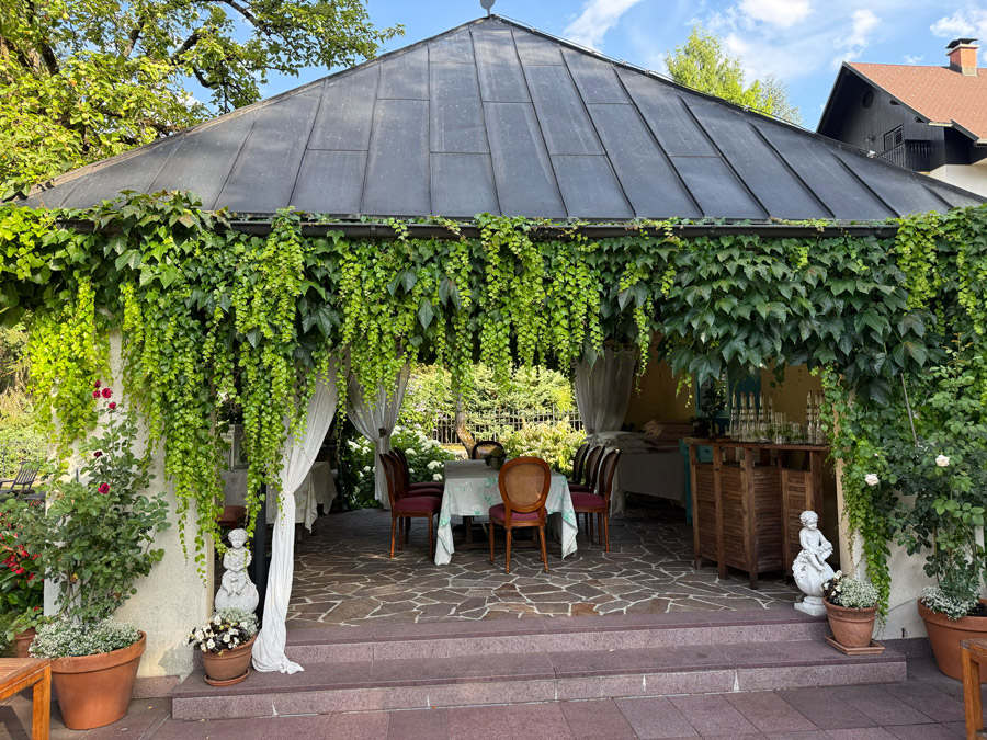 Vine-covered outdoor dining pavilion in the garden at Kendov Dvorec