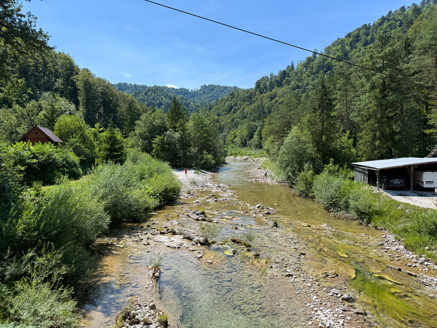 Clear river flowing through the forested valley of Idrijska Bela