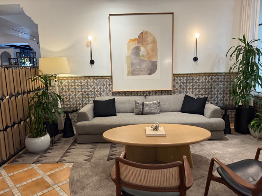 Sofa, artwork, plants, and patterned tile in the Kimpton Canary Hotel lobby